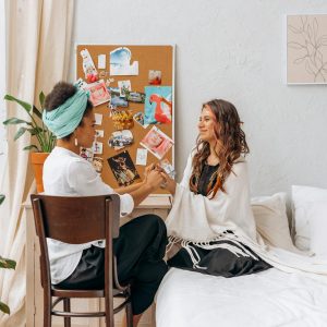 Woman in White Long Sleeve Shirt Sitting on Bed